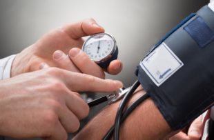 Close-up Of A Doctor's Hand Checking Blood Pressure Of A Patient