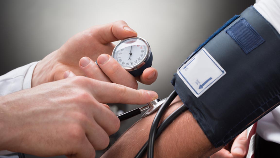Close-up Of A Doctor's Hand Checking Blood Pressure Of A Patient