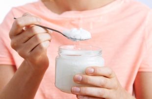 Woman With Spoonful Of Coconut Oil