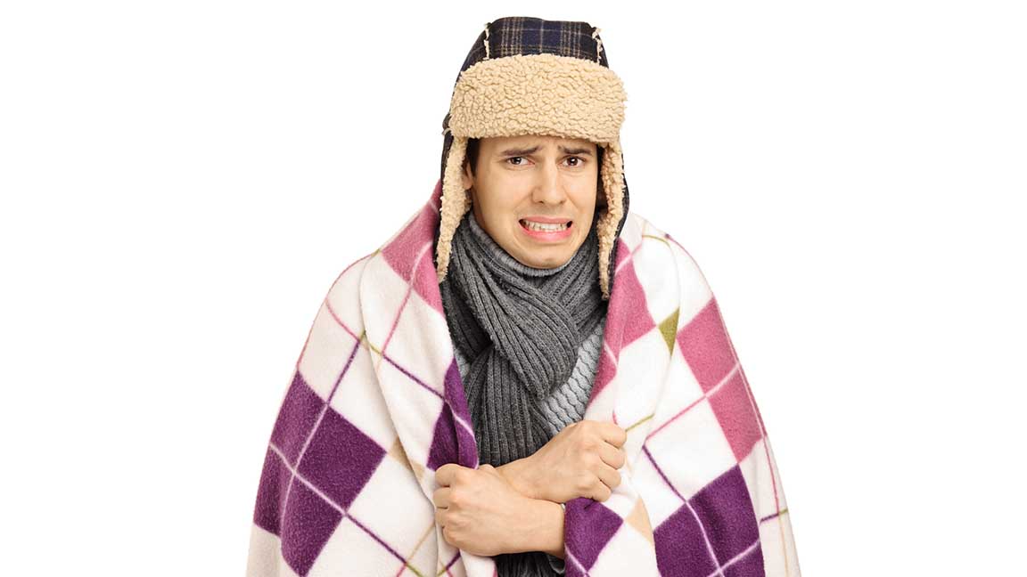 Young man covered with a blanket feeling cold isolated on white background