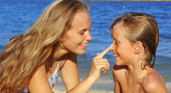 Brother and sister applying sunscreen