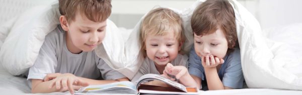 Three children read a book