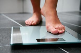 Individual with bare feet stepping onto scale