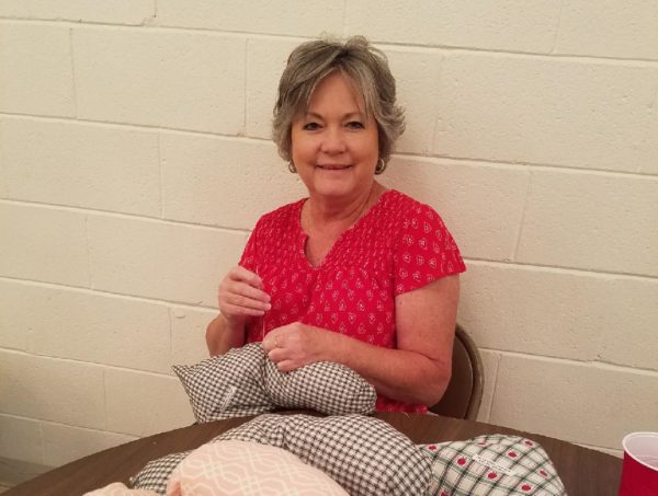 Breast cancer survivor Amanda Cribb helps craft one of the 212 post-surgical pillows donated by Pleasant Hill Baptist Church in Hemingway.