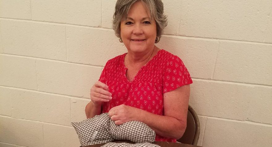 Breast cancer survivor Amanda Cribb helps craft one of the 212 post-surgical pillows donated by Pleasant Hill Baptist Church in Hemingway.