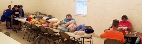 Members of the church and Vacation Bible School campers make pillows.