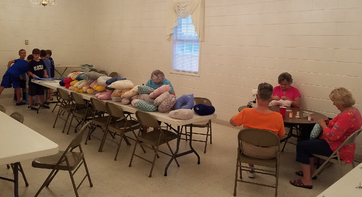 Members of the church and Vacation Bible School campers make pillows.