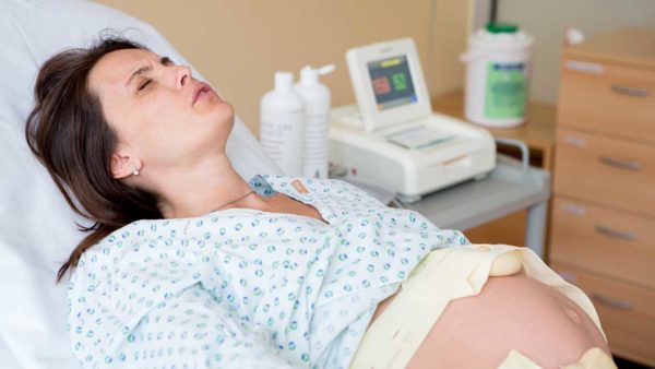 Pregnant woman in delivery room, having contractions