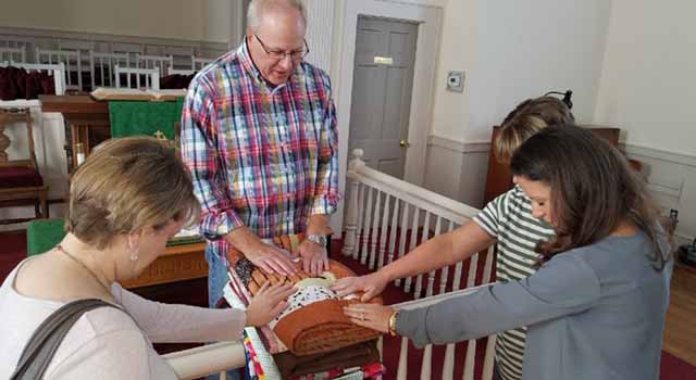 Socastee United Methodist Church Pastor Kurt McPherson blesses quilts created by the SUMC Stitchers. All quilts are blessed before they are donated.