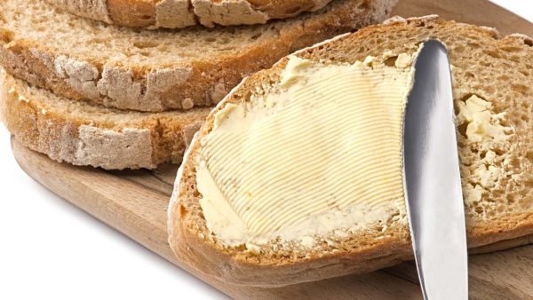 A knife spreading butter on bread