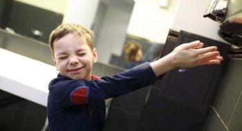 Boy drying his hands in a restroom