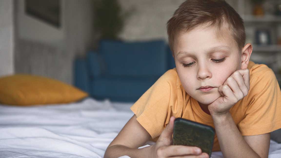 Child watching cell phone.