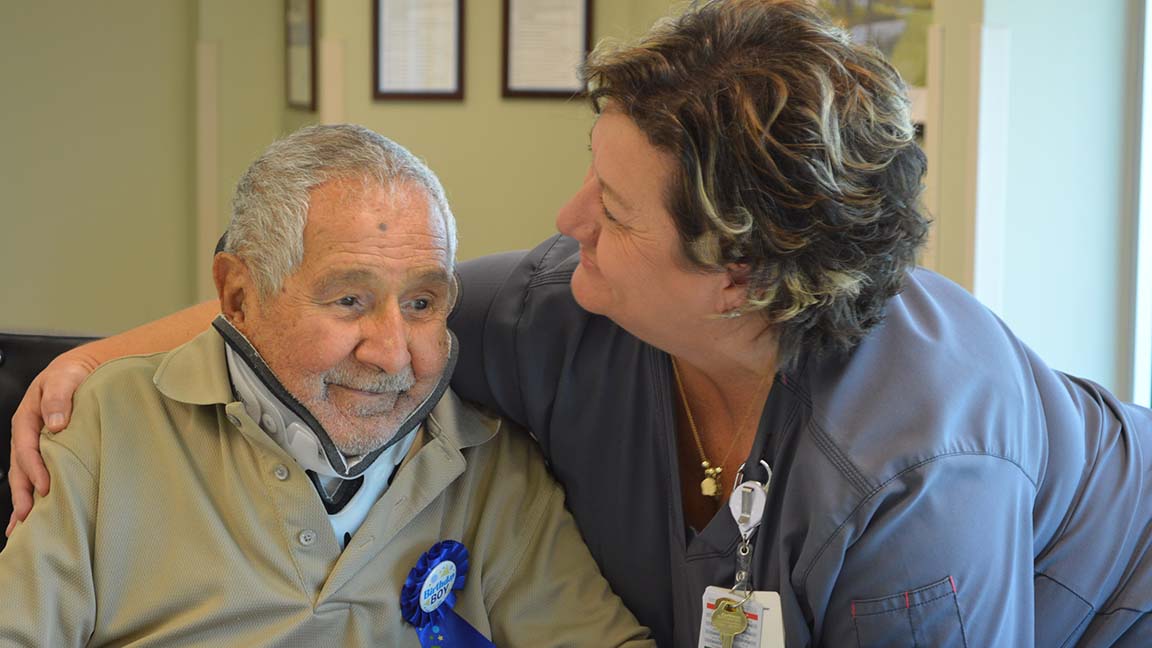 Deirdre Faulk, a nurse supervisor at Tidelands Health Rehabilitation Hospital, an affiliate of Encompass Health, embraces patient Oscar Sanchez during a party Saturday at the inpatient hospital celebrating his 100th birthday.