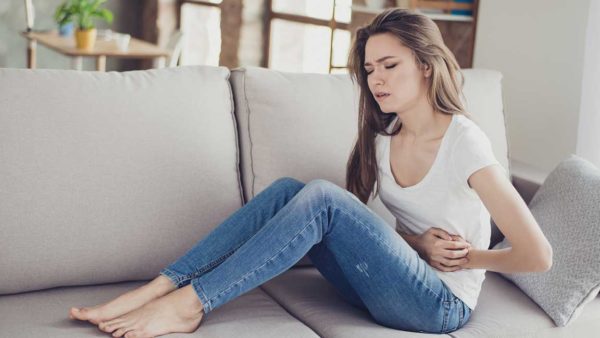 Woman struggles with abdominal pain.