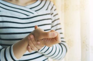 Woman massaging her arthritic hand and wris