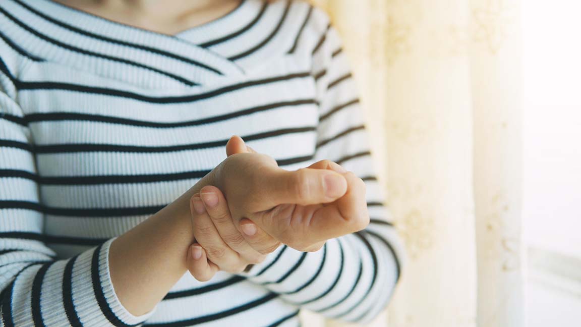 Woman massaging her arthritic hand and wris