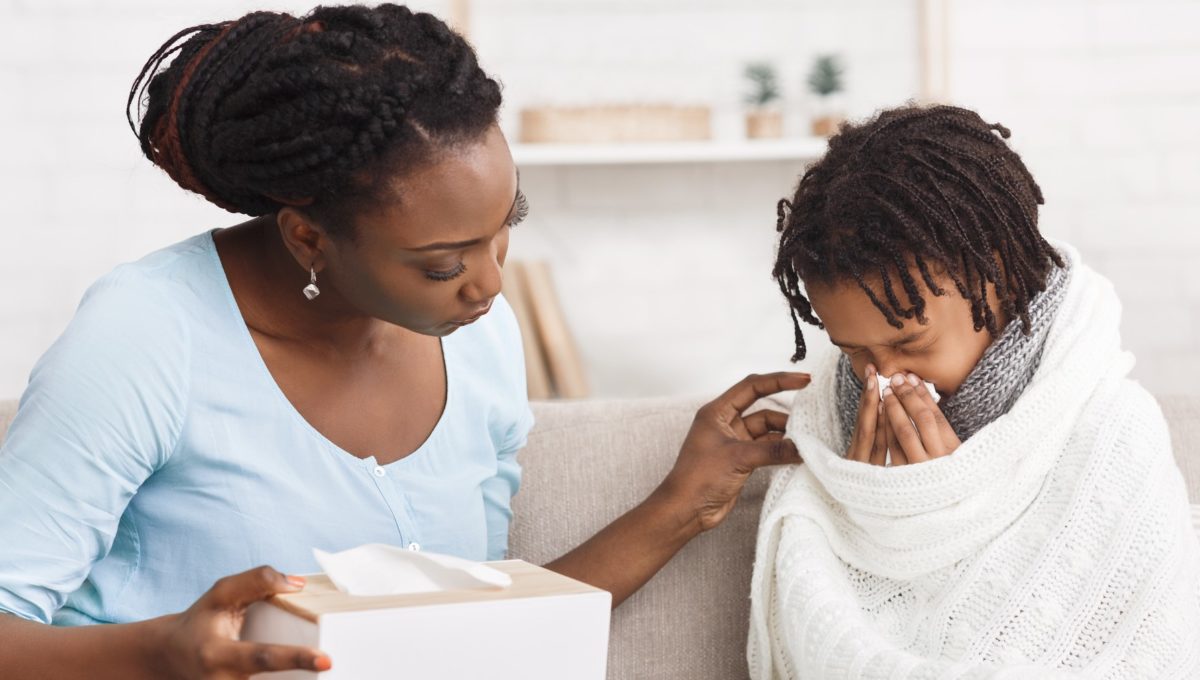 Woman comforts ill child