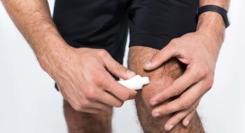 Man applying cream to knee.