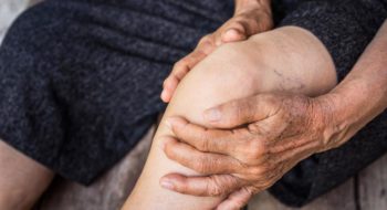 Older person holding knee