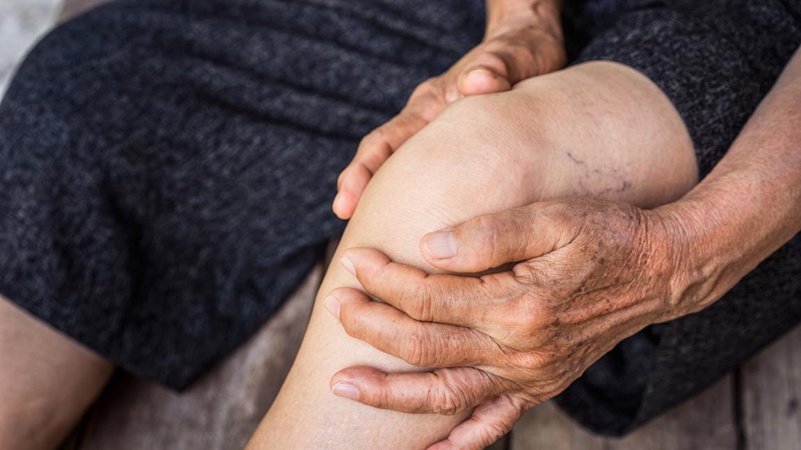 Older person holding knee