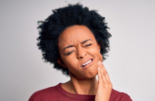 Young woman suffering from mouth pain.