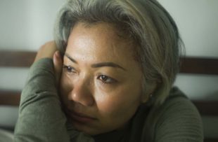 Tired woman staring out window.