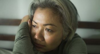 Tired woman staring out window.