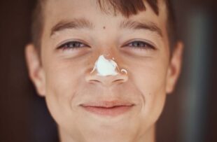 Happy boy with sunscreen on his nose