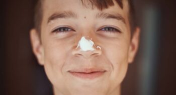 Happy boy with sunscreen on his nose