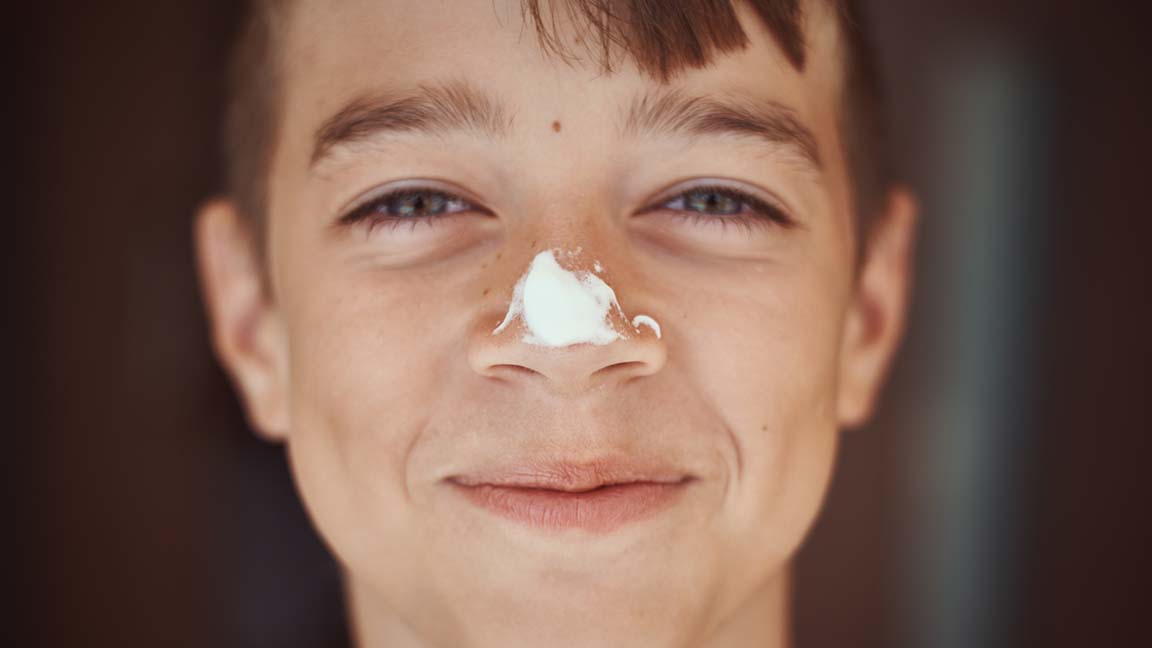 Happy boy with sunscreen on his nose