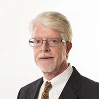 Headshot of man in black suit