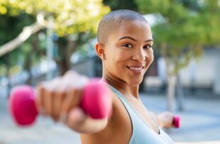 Woman exercising outside with weights