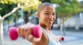 Woman exercising outside with weights