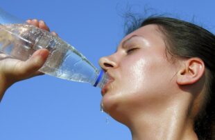 Sweaty woman drinking water.