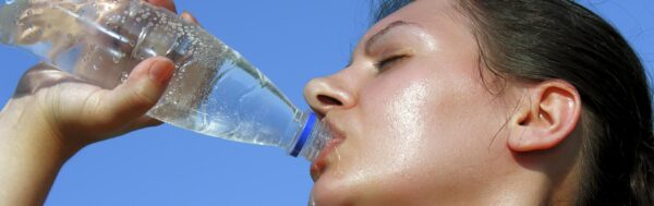 Sweaty woman drinking water.