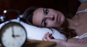 Woman lying in bed suffering from insomnia