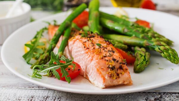 Baked salmon garnished with asparagus and tomatoes with herbs