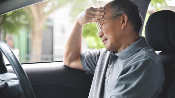 Man struggling with pain while driving