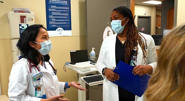 Dr. Klein speaking with a colleague.