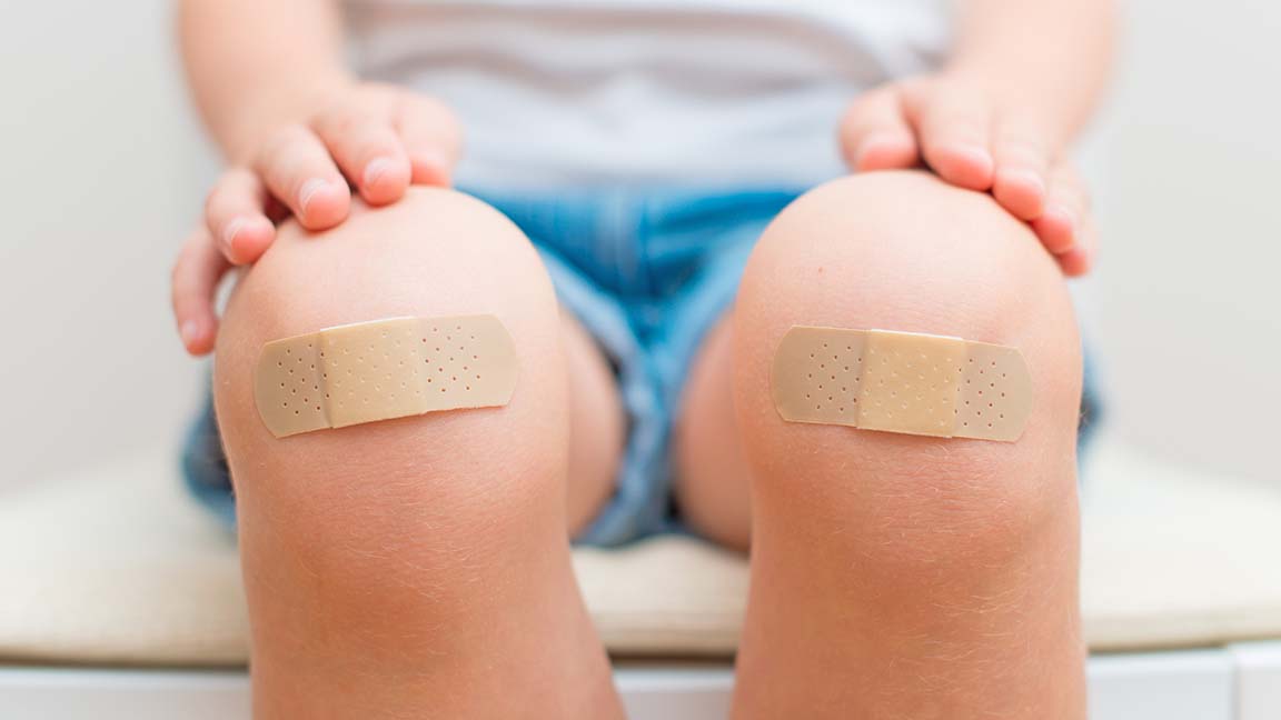 Child knee with an adhesive bandage.