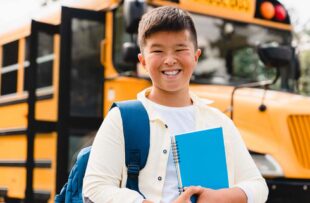 Child in front of school bus.