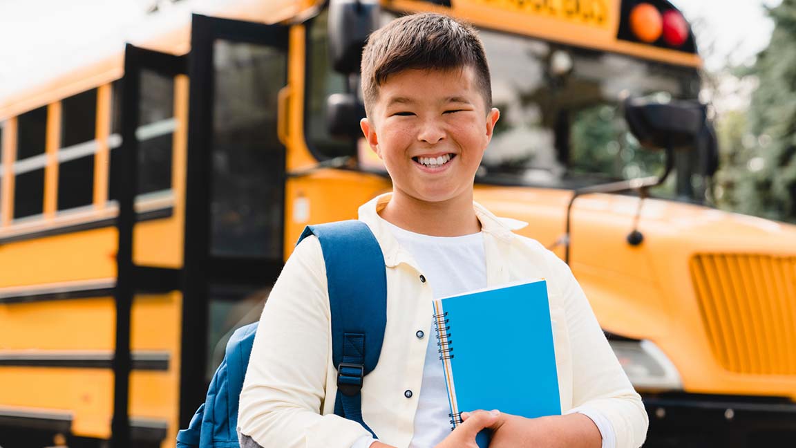 Child in front of school bus.