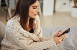 Woman at home using smartphone.