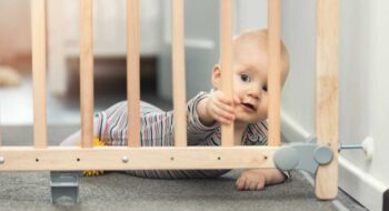 Child playing behind safety gate.