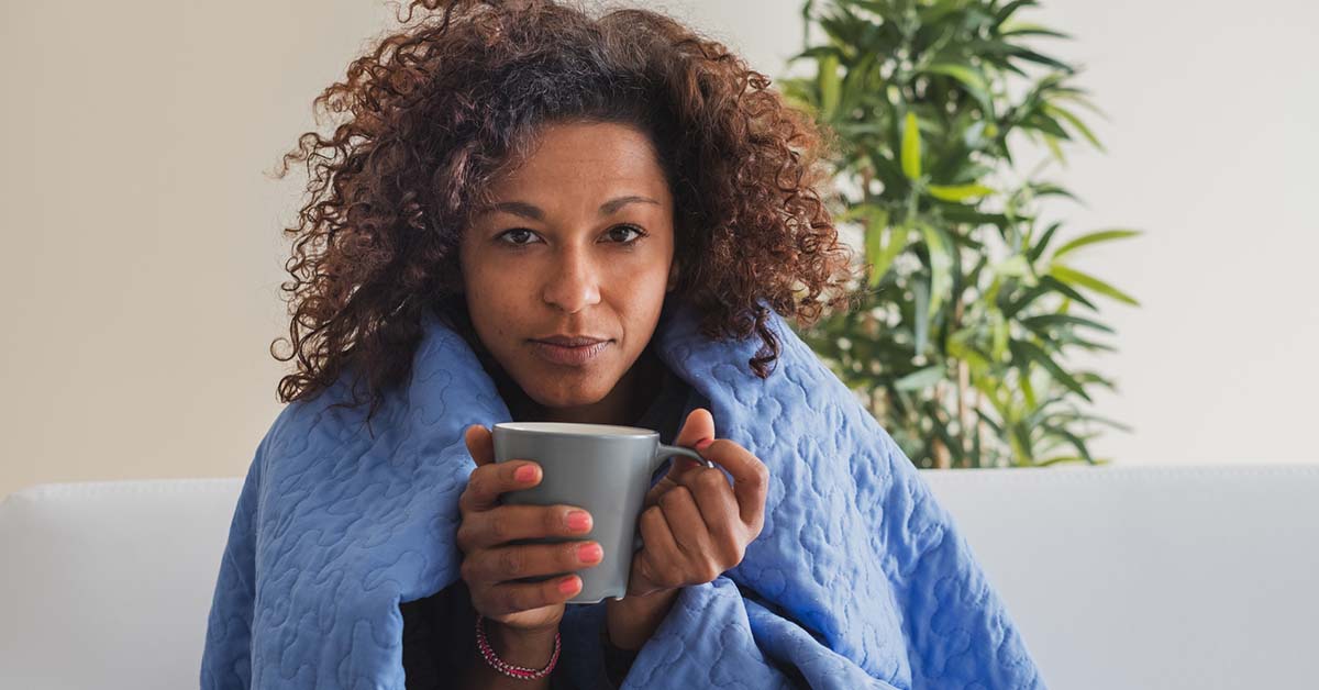 Sick woman drinks hot drink during cold weather