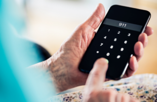 A woman holds a phone in her hands and dial 911