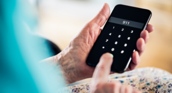 A woman holds a phone in her hands and dial 911