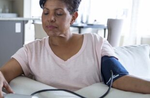 Woman checking blood pressure in living room