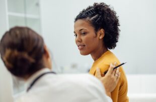 Physician reassuring female patient.