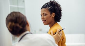 Physician reassuring female patient.